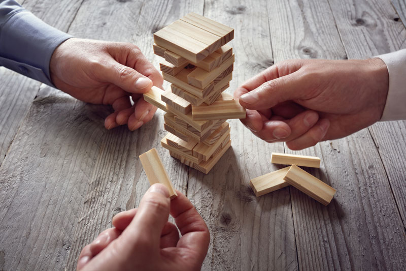 several people's hands playing Jenga game
