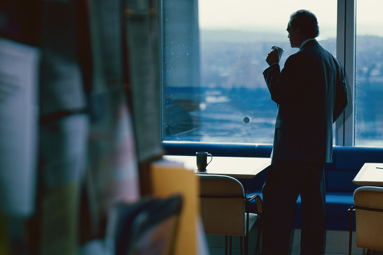 Business Owner Manager Looking out window with coffee