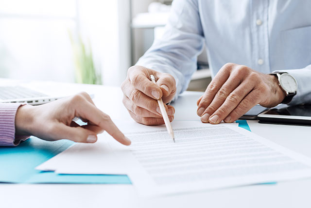 New employee filling out onboarding administration paperwork with HR consultant