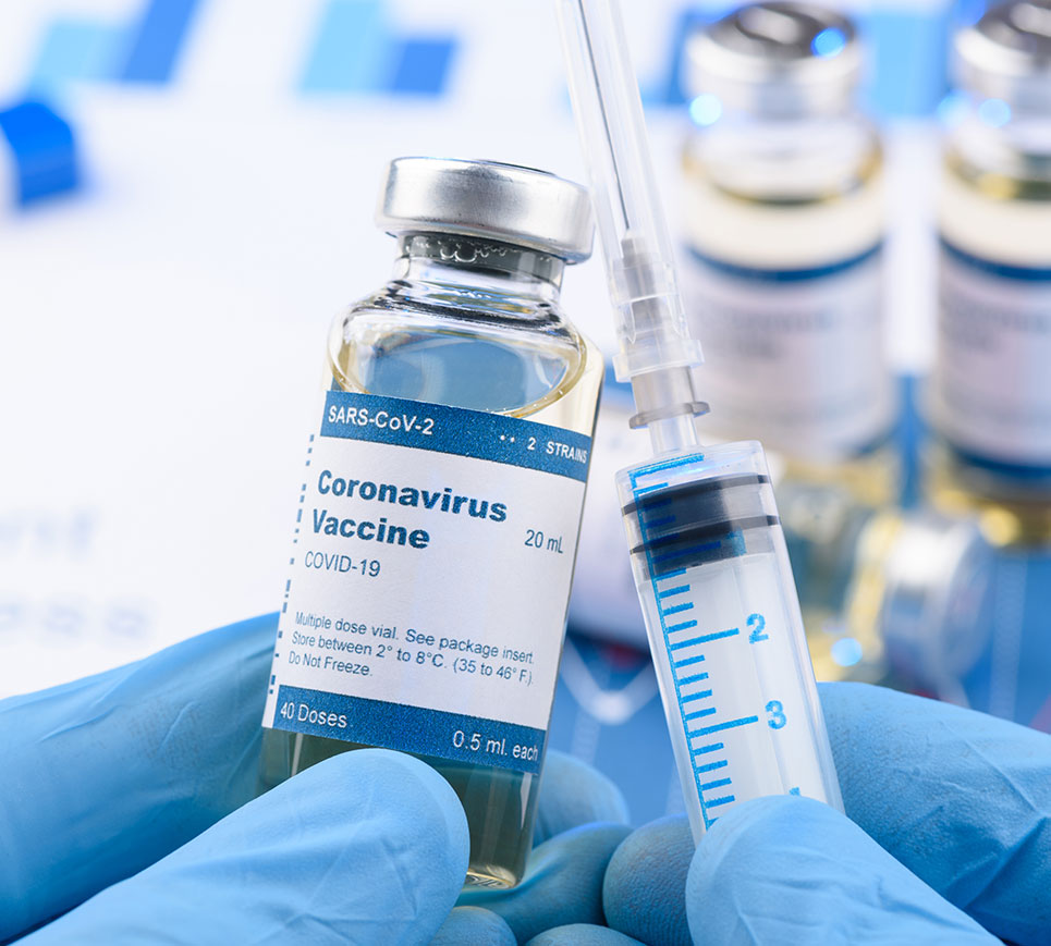 Doctor with blue gloves holding Covid-19 Vaccine with needle